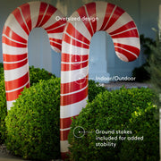 Two large inflatable candy canes with text indicating design, use, and stability features.